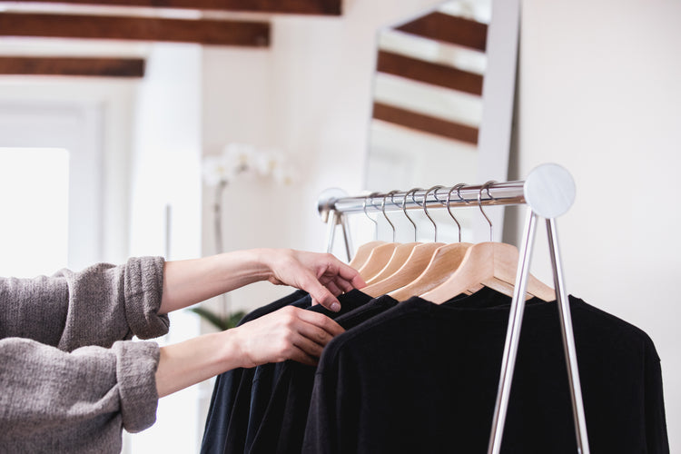 comparing-black-t-shirts-on-a-clothing-rack-in-a-sun-lit-shop